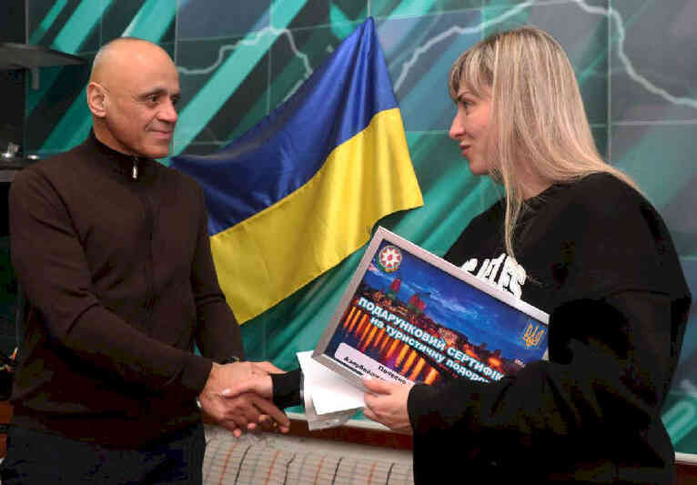 Почетный консул Республики Азербайджан вручает подарочный сертификат Елене Павленко