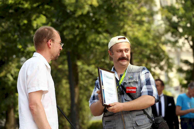 Олег Перегон получает награду за победу в творческом конкурсе журналистов